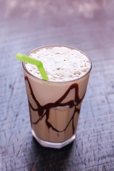 White Frappe Coffee Glass with iced drink on a dark wooden table in a cafe. — Stock Photo, Image