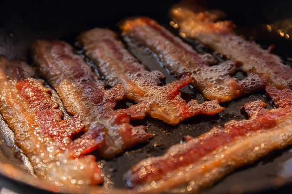 Strisce di pancetta o eritemi cotti in padella sotto i raggi del sole. Primo piano — Foto Stock