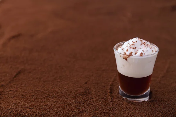 Kleine Tasse Piccolo Latte Macchiato auf einem Tisch mit gemahlenem Kaffee als Hintergrund — Stockfoto