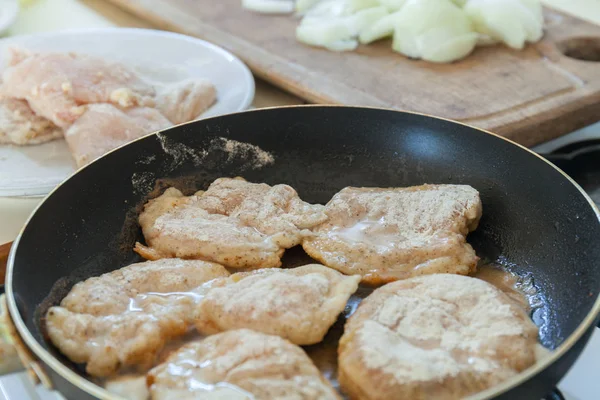 Freír filete de pollo crudo empanado en sartén. Haciendo la cena . — Foto de Stock