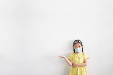 Asyalı çocuk ya da çocuk soğuk öksürük hastalığına yakalanmış N95 maskesi takıyor ve beyaz arka planda bulunan duman ve el puanı ile grip virüsünü veya PM2.5 toz bakterisini koruyor.