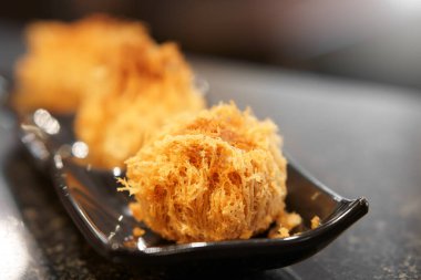 Siyah tabakta ya da tabakta kızarmış Taro ve ahşap masa ve kafeteryada beyaz ışık altın aperatif ya da öğle ya da kahvaltı ve akşam yemeği ile çıtır tatlı