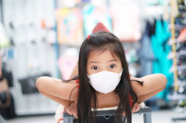 Asyalı çocuk ya da çocuk, PM2.5 tozu ya da Coronavirus covid-19 'u korumak için nezle öksürüğü için ağzı kapalı beyaz maske takar. Uykunun ya da alışveriş merkezinde ya da tatilde gülümseyin.