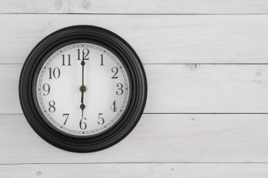 Saat tam altıda saat yönünde siyah-beyaz duvar saati. Çalışma saatleri için saat 6 'da ya da 6' da. Okula başla ya da sabah beyaz ahşap duvarda ya da boş alanlı üst görüş masasında uyanırsın.