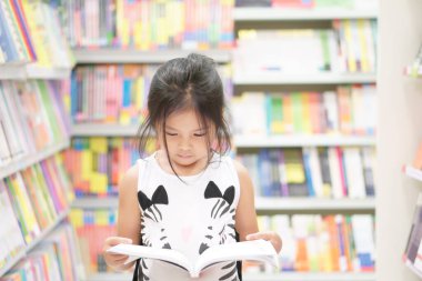 Anaokulunda ya da anaokulunda ya da çocuk yuvasında öğrenim görmek ve eğitim görmek için çocuk yuvasında mutlu bir gülümseme ve alışveriş ya da kitaplıkta bilgi veya ders kitabı seçmek.