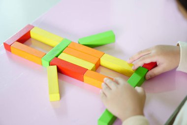 Çocuk ya da çocuk, anaokulunda robot ve yaratıcı yeni bir fikir inşa etmek için hayal gücü ya da fantezi kullanarak renkli tahta blok oyuncağı oynuyorlar.