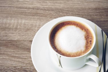 Sabah kahvaltı için beyaz bardakta süt köpüklü sıcak kapuçino ya da moka kahve. Cafe kahvede ve restoranda ya da klasik bir ofiste sabah kahvaltısı için içecek.