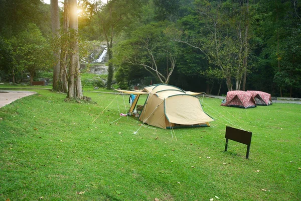 緑のジャングルの木や夏の冬の休暇のための森の滝のキャンプテントリラックスして休暇旅行牧草地の草や太陽の光でトレッキングやピクニックで旅行Khlong Nam Lai滝 — ストック写真