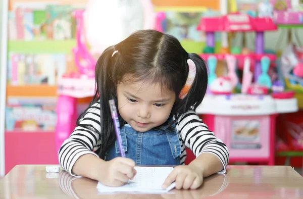 アジアの子供はかわいいか子供の女の子は書くことや勤勉なレビューを笑って 数学の宿題をしたり 保育園や家庭や幼稚園で白い紙や本で幸せな学習や訓練を楽しむ — ストック写真