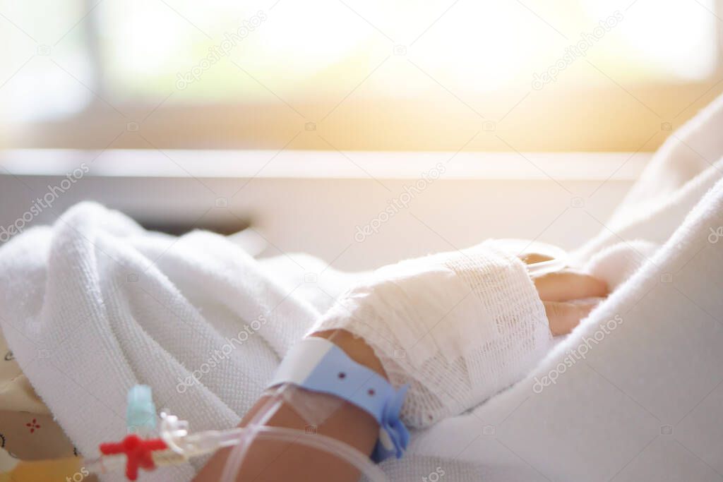 child or kid patients or sick in pediatric hospital with salt water or saline in blood vessels on hand for treatment healthcare and sleep rest on bed in hospital room from fever on warm sunlight