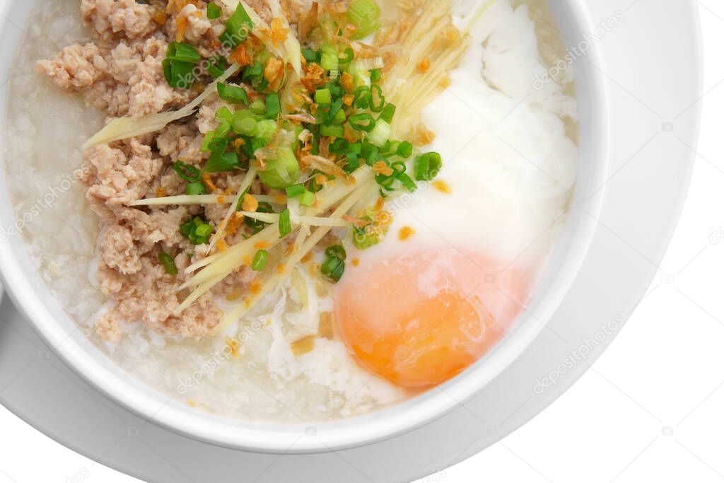 pork chops rice porridge or congee with soft boiled egg and vegetable in white bowl with spoon on top view for delicious breakfast and clean food in morning isolated on white included clipping path