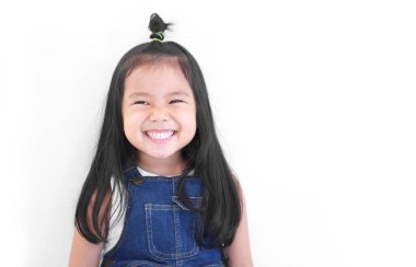 Asyalı çocuk ya da çocuk şirin ya da anaokulu öğrencisi mutlu gülümser beyaz dişler ve gülerek yeni bir fikir düşünür diş hekimi ya da anaokulunda beyaz arka planda kot pantolon giyer ve beyaz bir arka planı vardır.