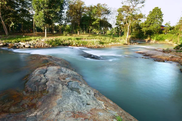 stream or rapids river with tree and rock or stone and cottage in green jungle or forest on warm sunlight for summer or winter holiday relax and vacation travel trip at National Park