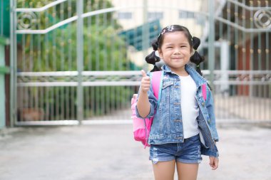 Asyalı çocuklar ya da kız çocuklar gülümseyecek ve mutlu mesut yaşayan bir öğrenci omuz çantası olacak ve başparmağınla okula ya da okula geri dönüp yaz eğitiminden ya da öğrenmeden sonra anaokuluna gideceksin.