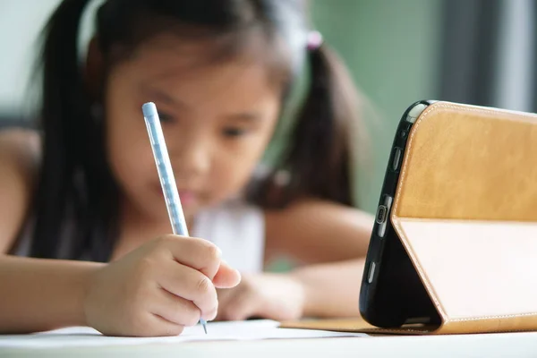 アジアの子供の学生に戻る学校や子供の女の子の笑顔書き込みノートや鉛筆で描画し 新しいアイデアや人々がスマートフォン上でオンライン家庭学習から学ぶために宿題を行うとコンピュータタブレット上で読みます — ストック写真