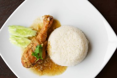 Tavuk budu, salatalık ve kişniş ile sulu salatalık suyu ya da yeşil sebzeli beyaz tabak ve siyah ahşap masa üzerinde kahvaltı ya da öğle ve akşam yemeği için restoranda ya da üst manzarada yemek salonunda