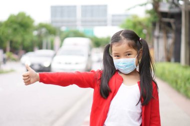 Asyalı çocuk ya da çocuk yüz maskesi takıyor. Ağzı kapalı ve nezle olmuş. PM2.5 tozu, koronavirüsü ve bakterileri korumak için.
