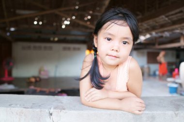 Asyalı çocuklar şirin ya da küçük kız ve köylü çocuğu Gülümseyen fakir eski ahşap ev ve terasta geleneksel bluz veya kolsuz gömlek giyerler