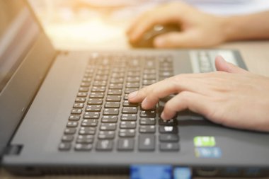 İş adamının eli bilgisayarın klavyesinde çalışmak ve İnternet 'i çalmak için ya da ofisteki e-postayı güneş ışığıyla kontrol etmek için.