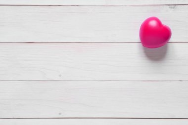 Eski beyaz ahşap masada pembe kalp kauçuğu ve Sevgililer Günü 'nde aşk anıtı ya da romantik manzarası ve boşluklu kalp sağlığı geçmişi