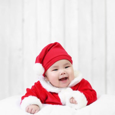 Asyalı çocuklar şirin ya da çocuk ve bebek Noel Baba kıyafeti giyiyor ve kışın beyaz ahşap duvarda Noel veya Noel için gülümsüyor ve uzay ile mutlu bir yeni yıl.