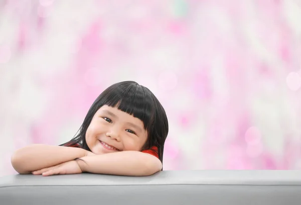 アジアの子供たちかわいいまたは子供の女の子幸せな楽しさと笑顔で赤いシャツでソファの上に就学前や保育園でピンクのボケの背景にある子供病院スペース — ストック写真