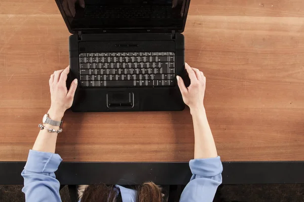 the secretary holds the computer with both hands, view from above