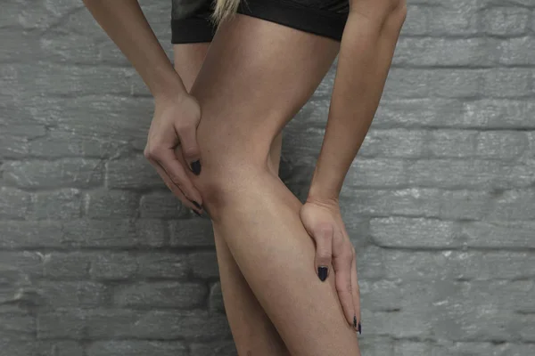 woman shows that she has calf pain