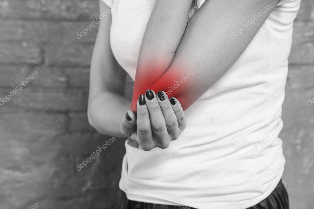 woman shows that her elbow hurts, black and withe