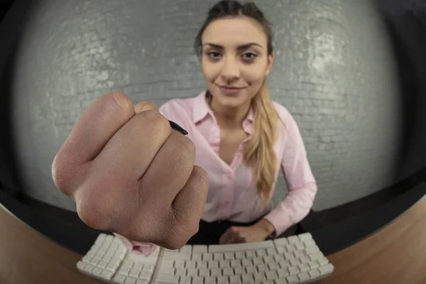 business woman threatens with fist, blurry background, fist in front of the camera