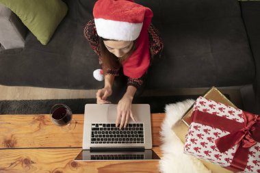 bir Noel şapka alışveriş yalnız kız online, bir dizüstü bilgisayar kullanarak