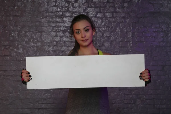 Beautiful young girl holding an empty board, copy space for adve — Stock Photo, Image