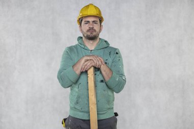 inşaat işçisi elinde bir tahta parçası tutar,