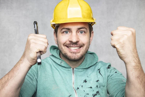 Stavební pracovník drží klíč v rukou, klíč jako — Stock fotografie