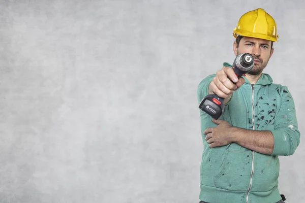 Stavební pracovník drží v Han elektrický šroubovák — Stock fotografie