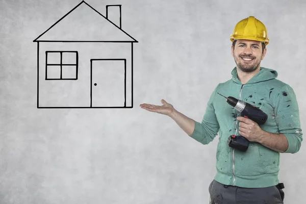 The construction worker holds an electric screwdriver in his han — Stock Photo, Image