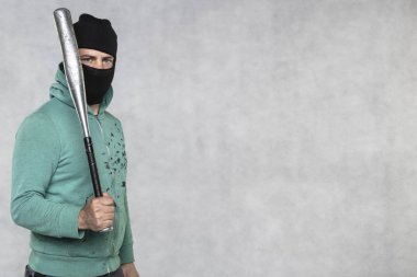 Maskeli bir holigan elinde bir beyzbol sopası tutar