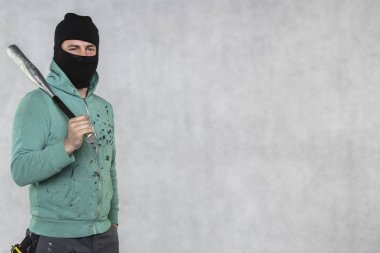 Maskeli bir holigan elinde bir beyzbol sopası tutar