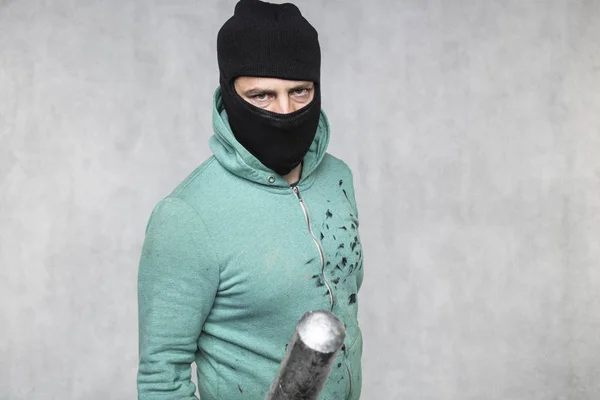 En maskerad huligan innehar ett basebollträ i handen — Stockfoto