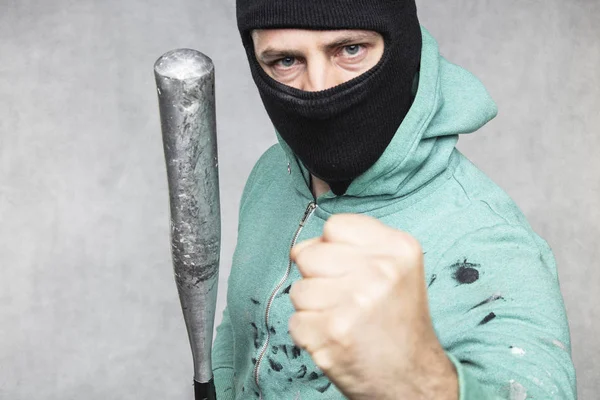 Um hooligan mascarado segura um taco de beisebol em sua mão — Fotografia de Stock