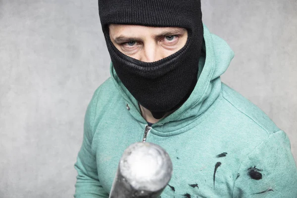 En maskerad huligan innehar ett basebollträ i handen — Stockfoto