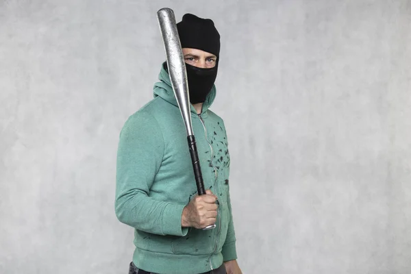 En maskerad huligan innehar ett basebollträ i handen — Stockfoto