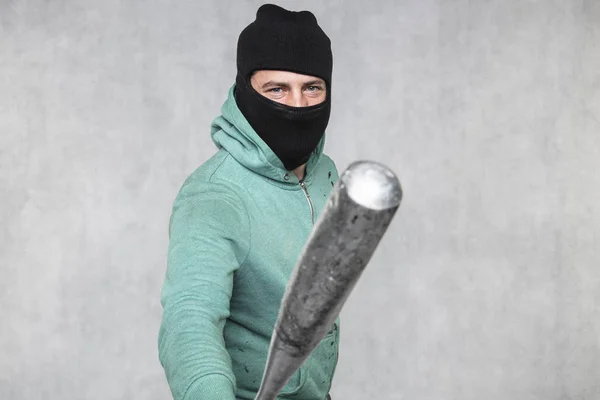 Un hooligan masqué tient une batte de baseball dans sa main — Photo