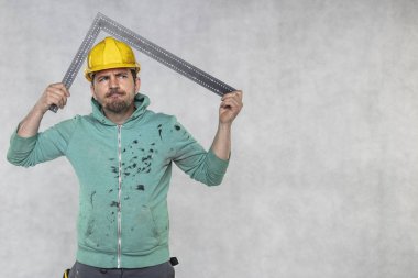 inşaat işçisi elinde bir açı tutuyor, bir rehber 