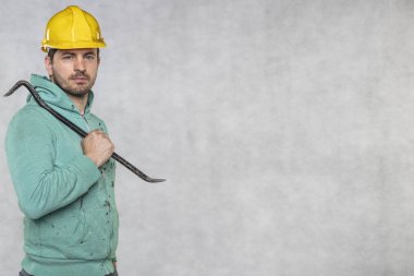 inşaat işçisi elinde bir iş aracı tutar, bir crowba