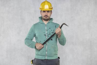 inşaat işçisi elinde bir iş aracı tutar, bir crowba