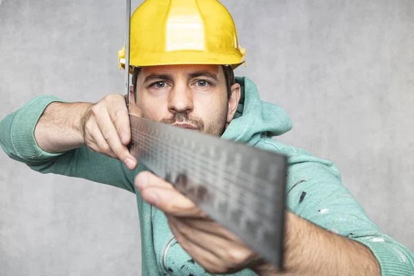 The construction worker is holding a angle in the hand, a guide — Stock Photo, Image