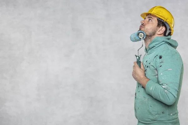 Un pintor satisfecho le da un rollo de pintura —  Fotos de Stock