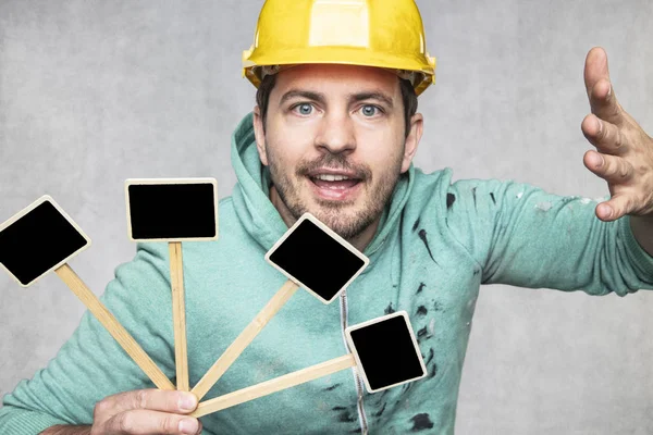 Construction worker holding a blackboard with space for text or — Stock Photo, Image