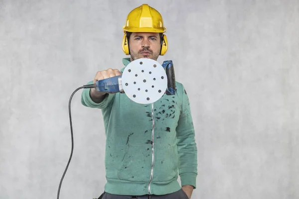 De bouwvakker toont het schuurpapier op de slijpmachine — Stockfoto